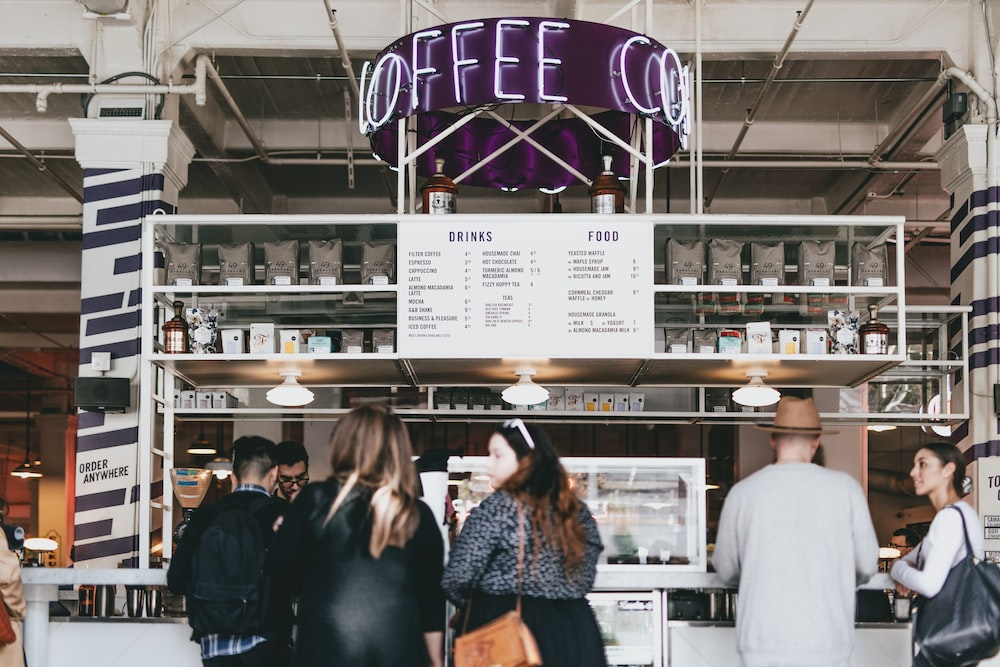 group-of-people-standing-in-front-of-food-stall-counter